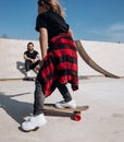 Father and his little son dressed in the casual clothes ride skateboards and have fun in a skate park with slides Royalty Free Stock Photo