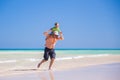 Father and his little son having fun and running on the beach. Royalty Free Stock Photo