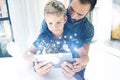 Father and his little son playing together on mobile computer, resting indoor.Bearded man with young boy using tablet PC Royalty Free Stock Photo