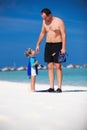 Father and his son having fun on the beach and getting ready to snorkle Royalty Free Stock Photo