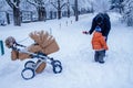 Father and his son playing outside, winter forest on the background, snowing, happy and joyful Royalty Free Stock Photo