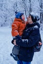 Father and his son playing outside, winter forest on the background, snowing, happy and joyful Royalty Free Stock Photo