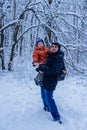 Father and his son playing outside, winter forest on the background, snowing, happy and joyful Royalty Free Stock Photo