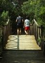 A father and his son walk on a wooden bridge