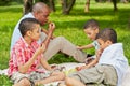 Father and his three sons sit on rag matting on