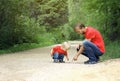 Father and his toddler son found the insect and inspect it. Kid exploring nature concept. Copy space