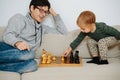 Father and his toddler son playing chess on a sofa at home Royalty Free Stock Photo