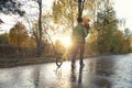 Father and his toddler son walking in the park on good autumn day. Dad holding kid in one hand and child`s bicycle in another. Royalty Free Stock Photo