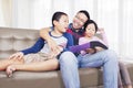 Father and his two children reading a book at home Royalty Free Stock Photo