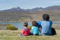 Father and his two sons relaxing for a moment and enjoying the views after a hard hiking in the mountains of Palencia, Spain