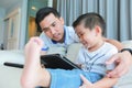 Father and his young son having fun by gaming on a tablet. Royalty Free Stock Photo