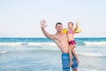 Father holding a baby high with happy face near the sea. Royalty Free Stock Photo