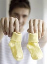 Father holding baby socks. Conceptual image