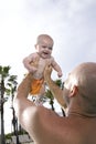 Father holding baby up high in sky Royalty Free Stock Photo