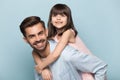 Father holding on back adorable preschool kid studio shot