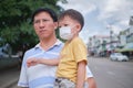 Father holding cute little Asian toddler boy child wearing protective medical mask, Concept of coronavirus quarantines and Air