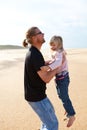 Father holding daughter in arms at the beach Royalty Free Stock Photo