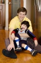Father holding disabled son on kitchen floor Royalty Free Stock Photo