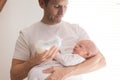 Father holding and feeding his newborn son with milk bottle at home. Royalty Free Stock Photo
