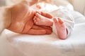 Father holding in the hands feet of newborn baby. Baby little feet in parents hand. Feet skin care closeup. Happy family Royalty Free Stock Photo