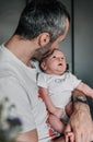 Father holding his baby and kissing him on the head - vertical shot