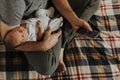 Father holding his baby while using his phone Royalty Free Stock Photo