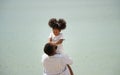 Father holding his daughter up high against sky. african american dady hug girl with sea background Royalty Free Stock Photo