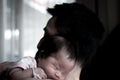 Father holding his newborn baby beside window. After Milk from mother`s breast is a natural medicine to baby. Mother day bonding c