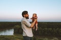 Father holding infant baby walking together outdoor