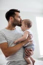 Father holding kissing his baby girl on forehead