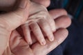 Father holding a newborn baby hand in his. Child hand closeup into parent hands together Royalty Free Stock Photo