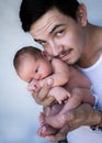 Father holding newborn baby up close to his face looking at the camera Royalty Free Stock Photo