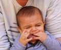 Father holding baby boy, teething, grumpy face Royalty Free Stock Photo