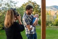 father holds baby in home garden. mother takes a picture of them Royalty Free Stock Photo