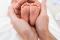 Feet of a newborn baby boy wrapped in the arms of his father Royalty Free Stock Photo