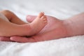 Father holds the feet of a newborn baby in his arms. Hands and feet on a white background close-up. Royalty Free Stock Photo