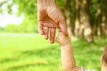 A Father holds the hand of a small child in the park on the nature vacation background