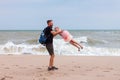 Father holds his cute daughter in arms, circles around himself, play have fun together on sea beach. Father`s Day family Royalty Free Stock Photo