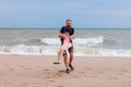 Father holds his cute daughter in arms, circles around himself, play have fun together on sea beach. Father s Day family Royalty Free Stock Photo