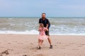 Father holds his cute daughter in arms, circles around himself, play have fun together on sea beach. Father`s Day family Royalty Free Stock Photo