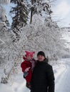 A father holds his little daughter in his arms during a walk in the winter forest. Royalty Free Stock Photo
