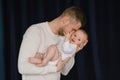 A father holds his newborn baby in his arms. Dad kisses his little son Royalty Free Stock Photo