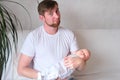 A father holds his newborn three month old son in his arms