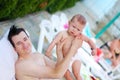 The father holds the little son in his arms and they rest together after swimming in the pool Royalty Free Stock Photo