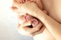 The father holds the newborn in his arms. Legs of a newborn in dad`s hands, the concept of a happy reliable family