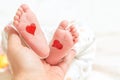 Father holds a small leg of a newborn baby. hearts for parents d Royalty Free Stock Photo