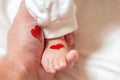 Father holds a small leg of a newborn baby. hearts for parents d Royalty Free Stock Photo