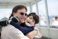 Father hugging disabled son on ferry boat