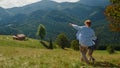 Father hugging son walking on mountain hill. Man going down green slope with boy Royalty Free Stock Photo