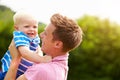 Father Hugging Young Son In Garden